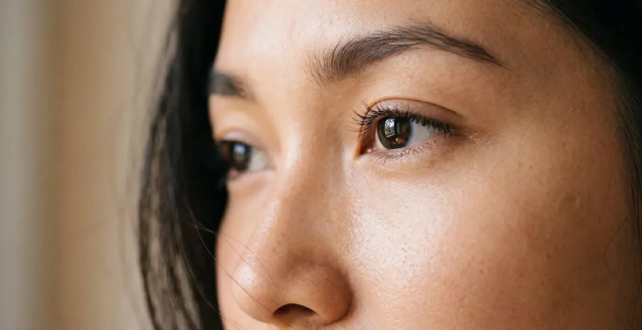 Gros plan du contour de l'oeil d'une femme avec une peau lisse et un regard reposé, illustrant un maquillage anti-cernes invisible