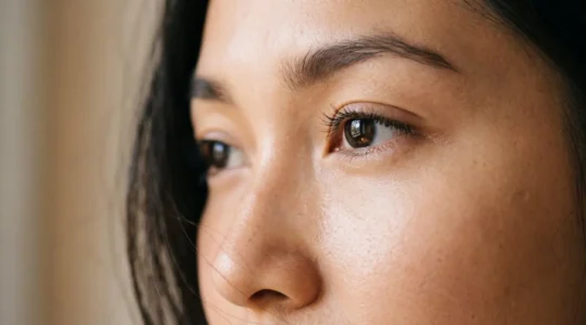 Gros plan du contour de l'oeil d'une femme avec une peau lisse et un regard reposé, illustrant un maquillage anti-cernes invisible