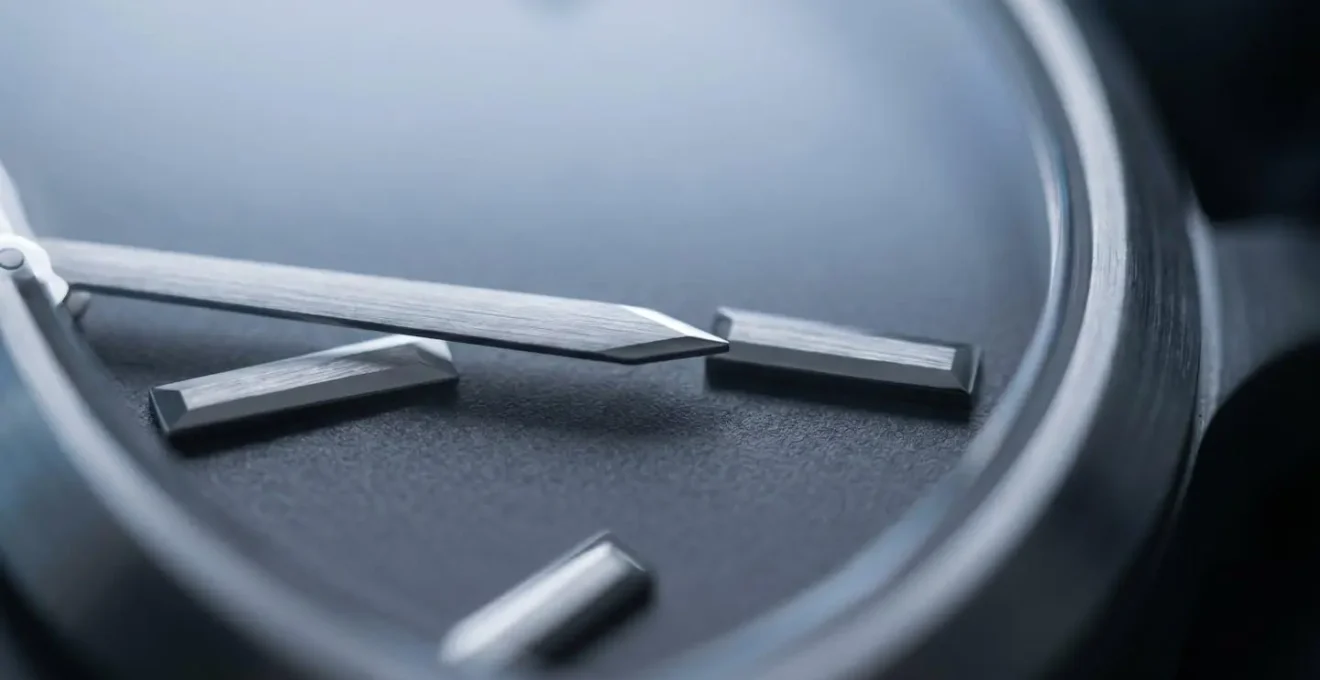 Gros plan détaillé d'une montre minimaliste élégante avec cadran épuré sous éclairage LED froid, mettant en valeur la lisibilité des aiguilles et la finition métallique sobre